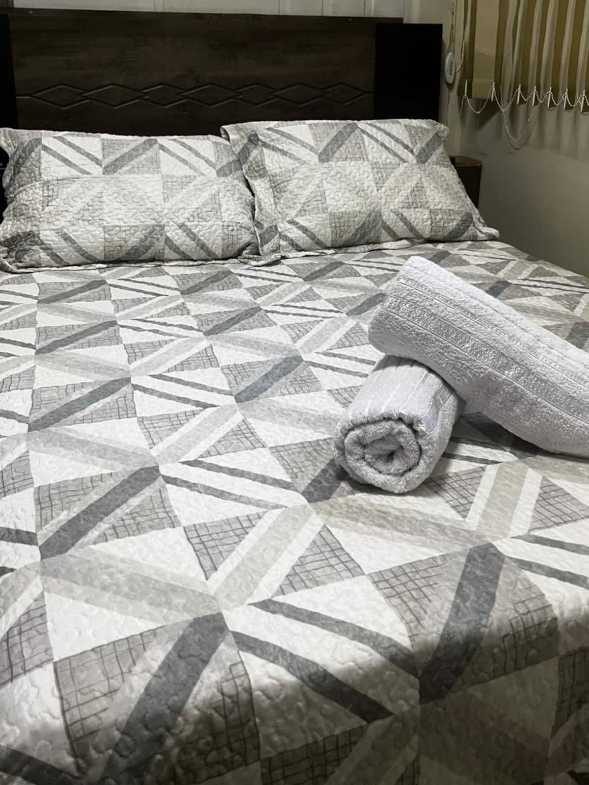 Cama de casal arrumada na Kitnet Paris